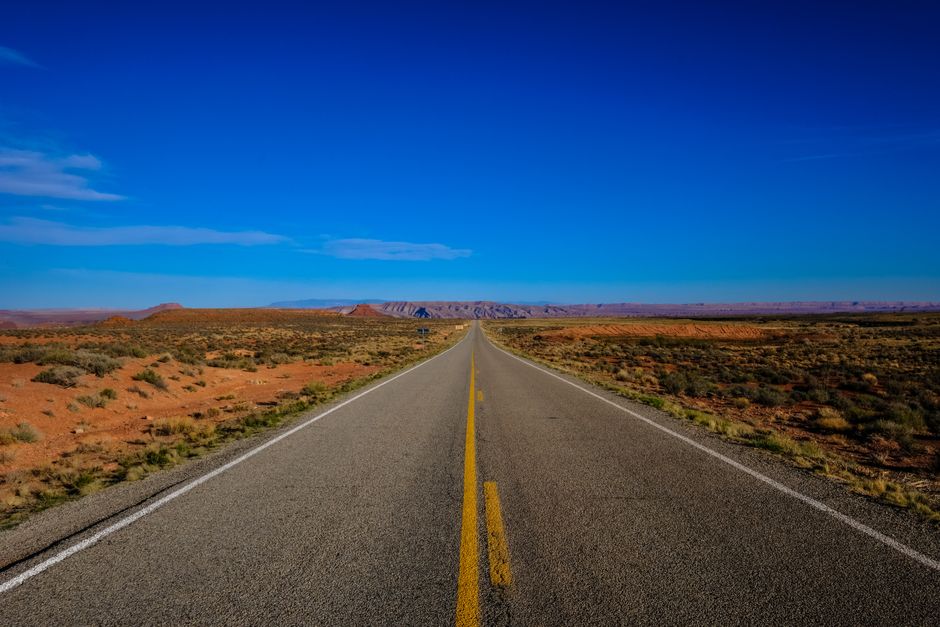Long, open highway stretching through the Arizona desert landscape towards a vibrant sunset, symbolizing a new path forwar...
